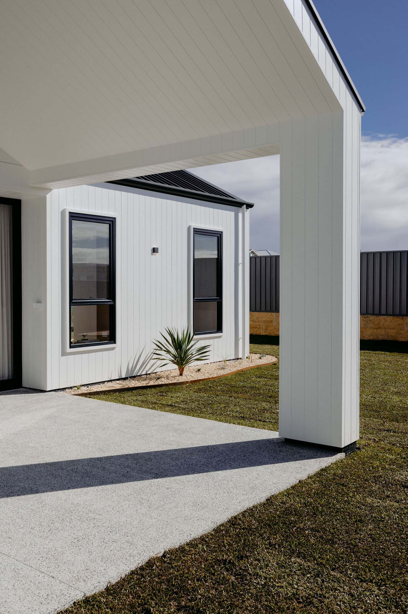 image1 Modern custom home exterior with white vertical cladding, black-framed windows, and covered alfresco area in South West Western Australia